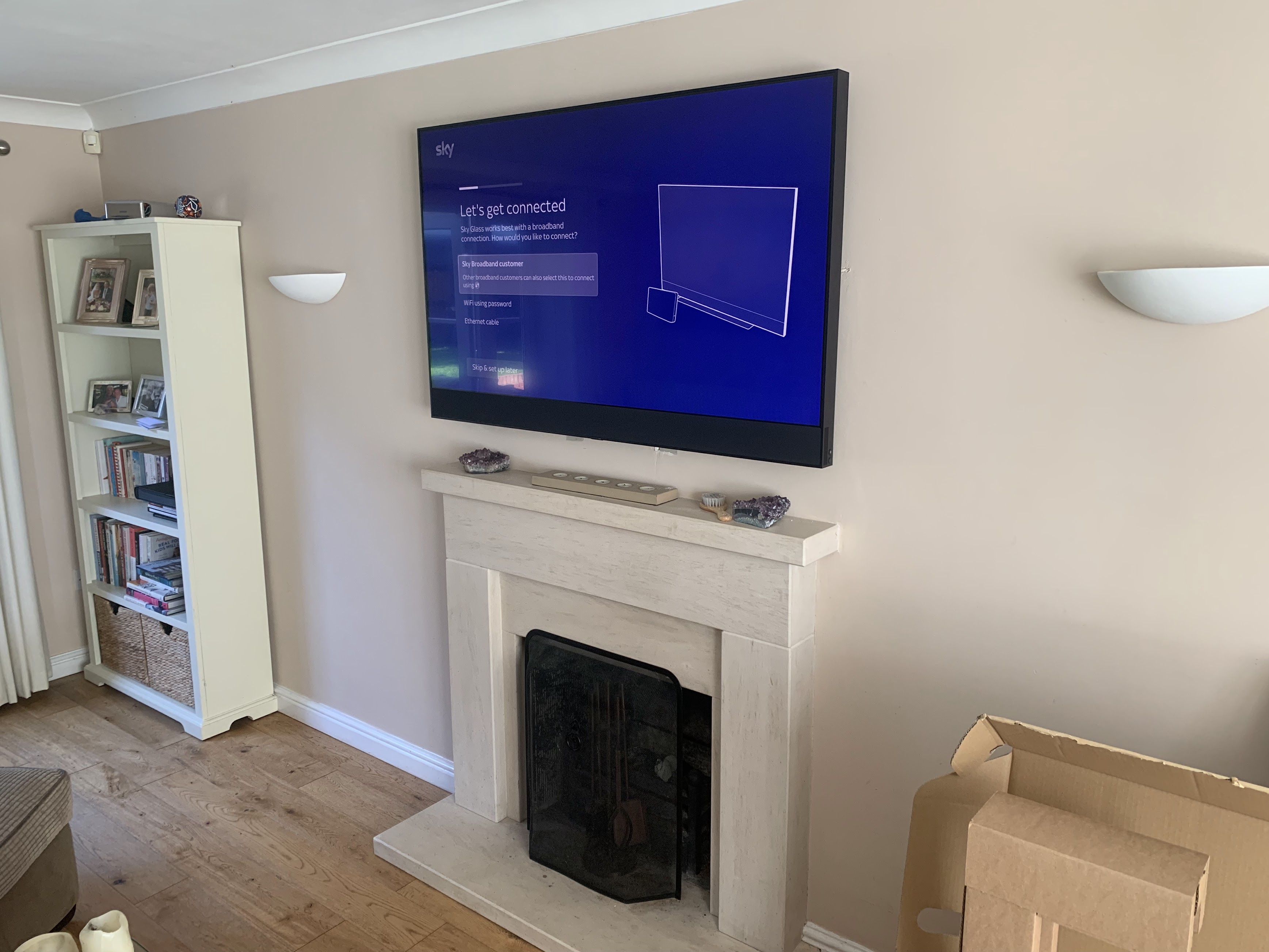 Sky Glass TV wall mounted above fireplace in Milton Keynes living room