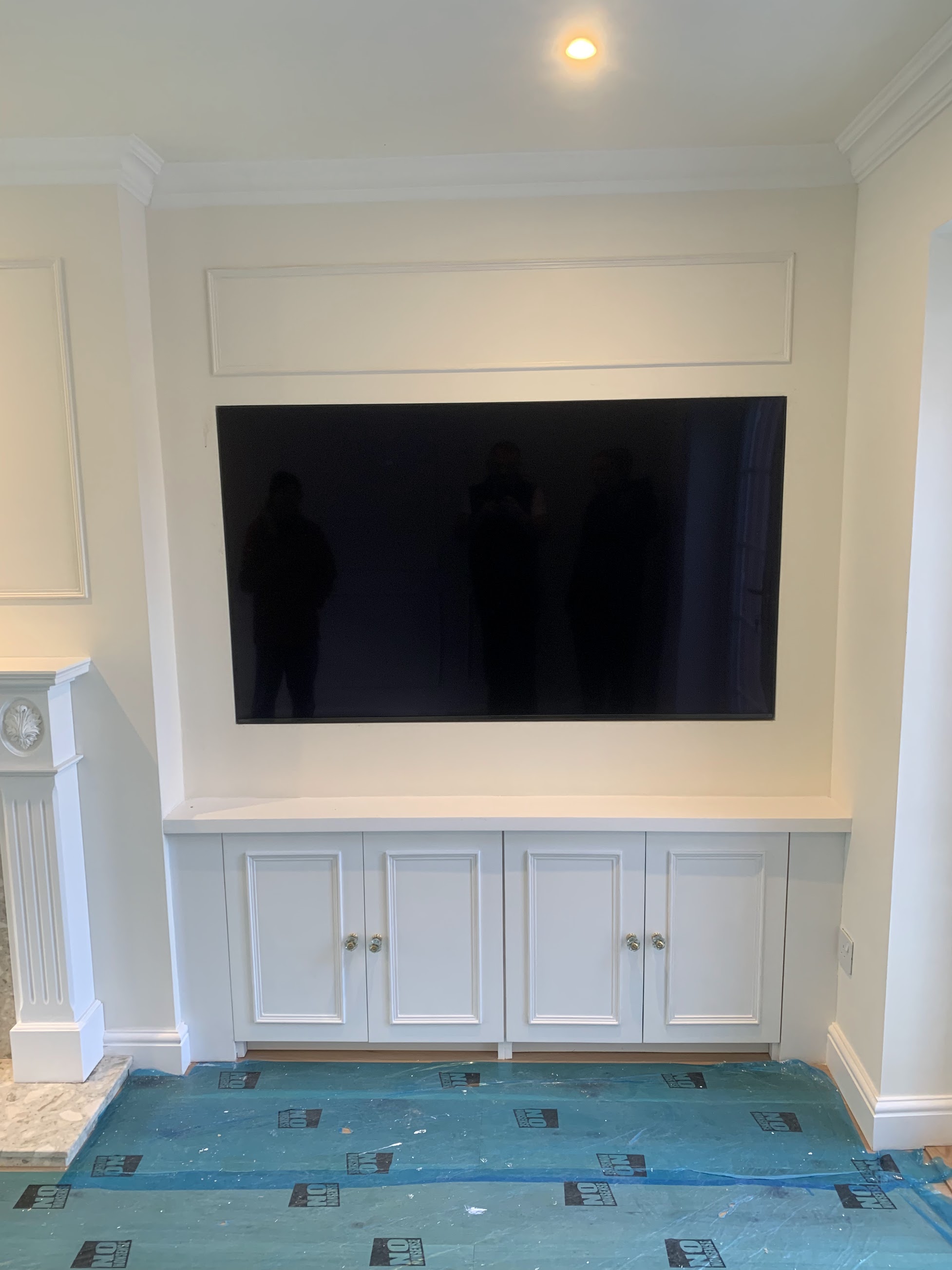 Large TV wall mounted in built-in alcove with custom cabinetry